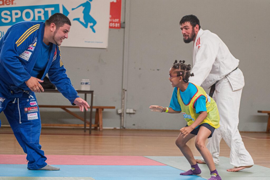 “ Je me suis sentie libre : c’était génial !”, jubile Grâce, 7 ans, après son « combat » improvisé avec Anthony Sarais, champion de jujitsu brésilien, qui s’est entraîné, lundi 8 juillet, avec les enfants présents au village Kinder.