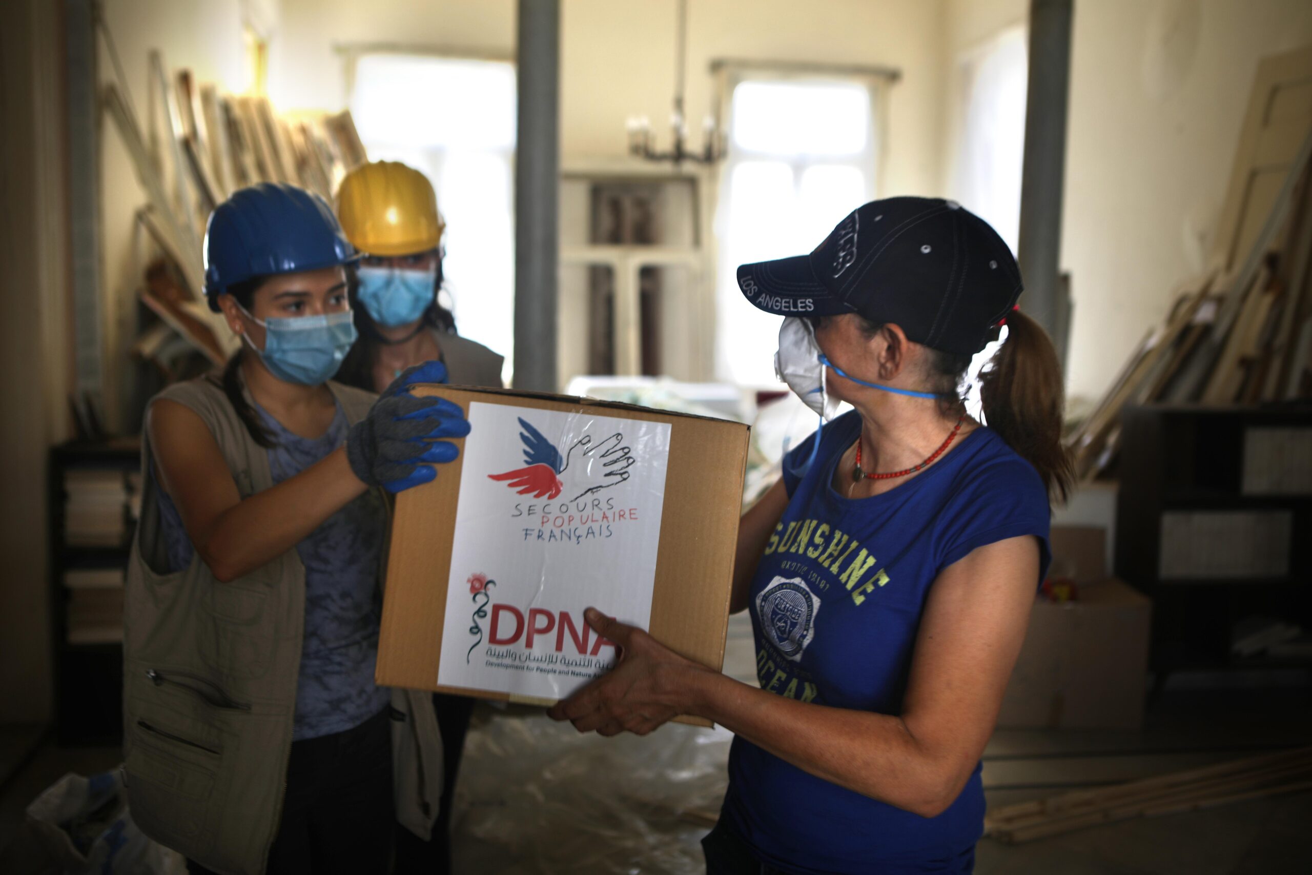 Les volontaires de DPNA remettent à Anna, dont la maison a été détruite, un colis d'urgence 