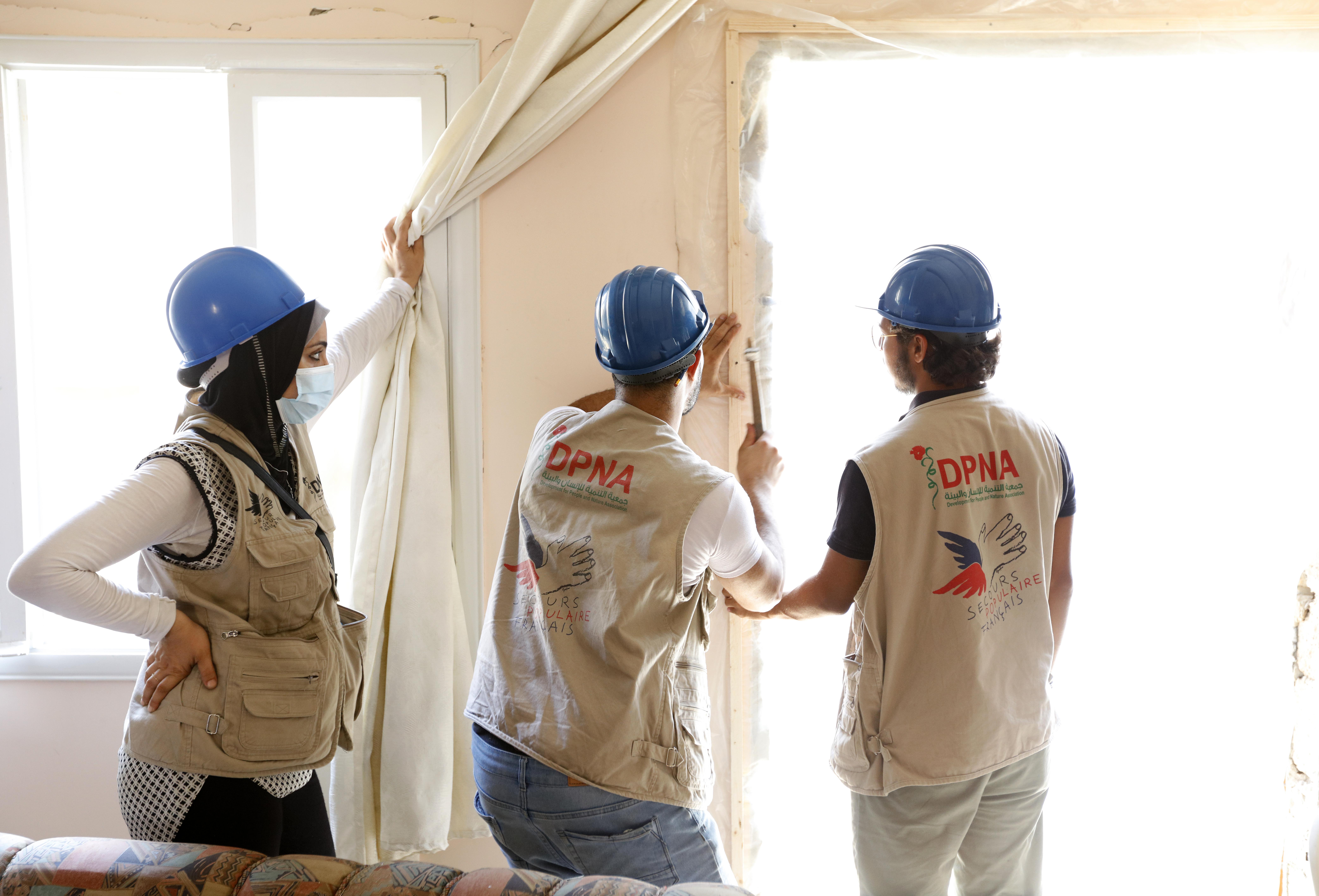 Trois volontaires de DPNA lors de travaux de réhabilitation d'un logement sinistré