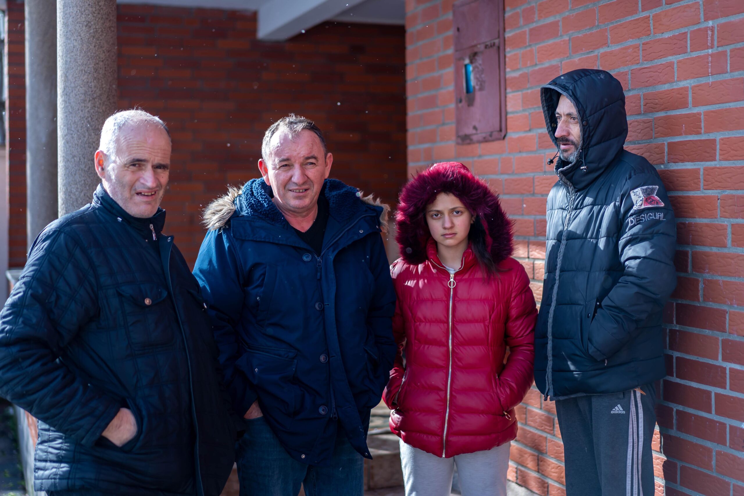 Eriona et sa famille sont soutenus par Handikos sur les plans alimentaire, sanitaire et moral. Elle est entourée par son père (à droite), ainsi que par Isak Hyseni, directeur de Handikos (à gauche) et Ilir Poterqoj, bénévole (à côté d’Eriona).©Jean-Marie Rayapen Kosovo : Handikos, le handicap à bras-le-corps