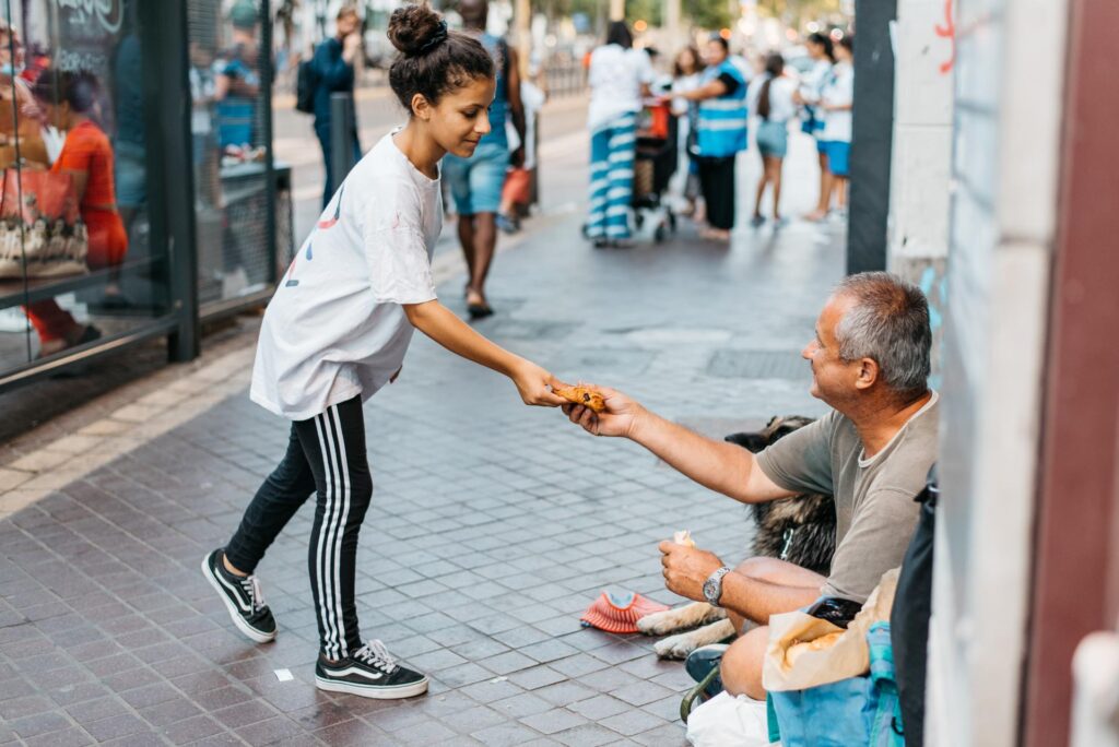 Isra, Copain du Monde à Marseille, remet à une personne sans-abri de quoi se restaurer.