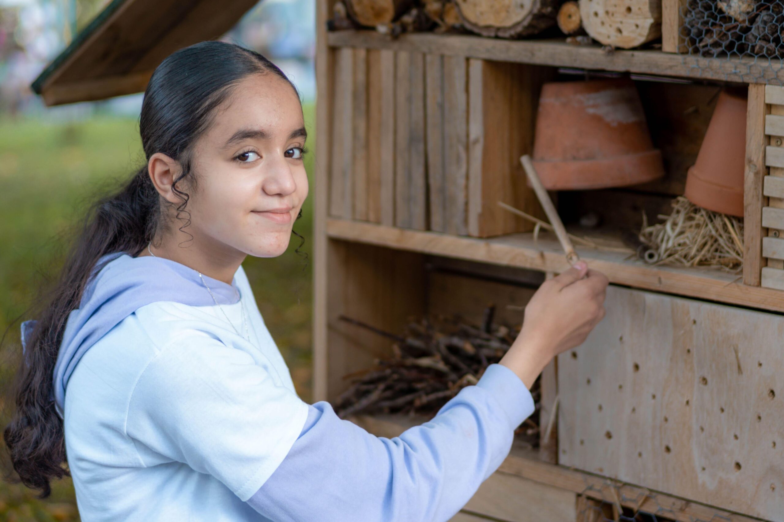 Doua, 13 ans, met la dernière main à l'hôtel à insectes, que les "Copain du Monde" ont fabriqué l'été dernier dans le but de protéger la biodiversité. Il est installé dans le parc des Dominicaines.