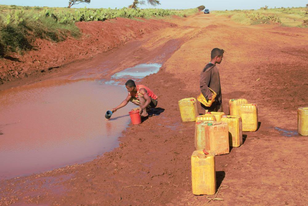 Des villageois remplissent des jerrycans dans des marres formées sur la piste. « La situation est considérée comme la première crise alimentaire au monde provoquée par le réchauffement climatique », souligne Adrien Thépot.