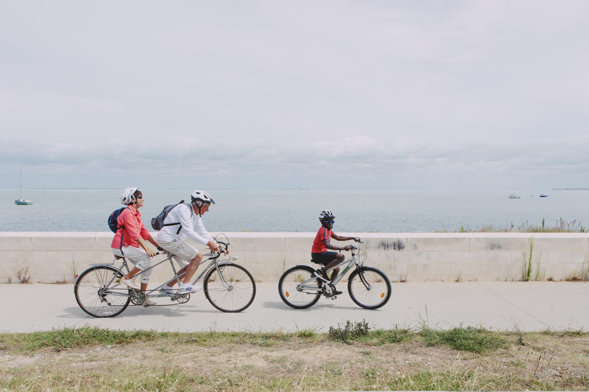 D’année en année, Reine et Pascal mesurent les progrès d’Eba en vélo. Cette année, ils peuvent faire une longue balade ensemble le long de la mer. Un, deux, trois... soleil !