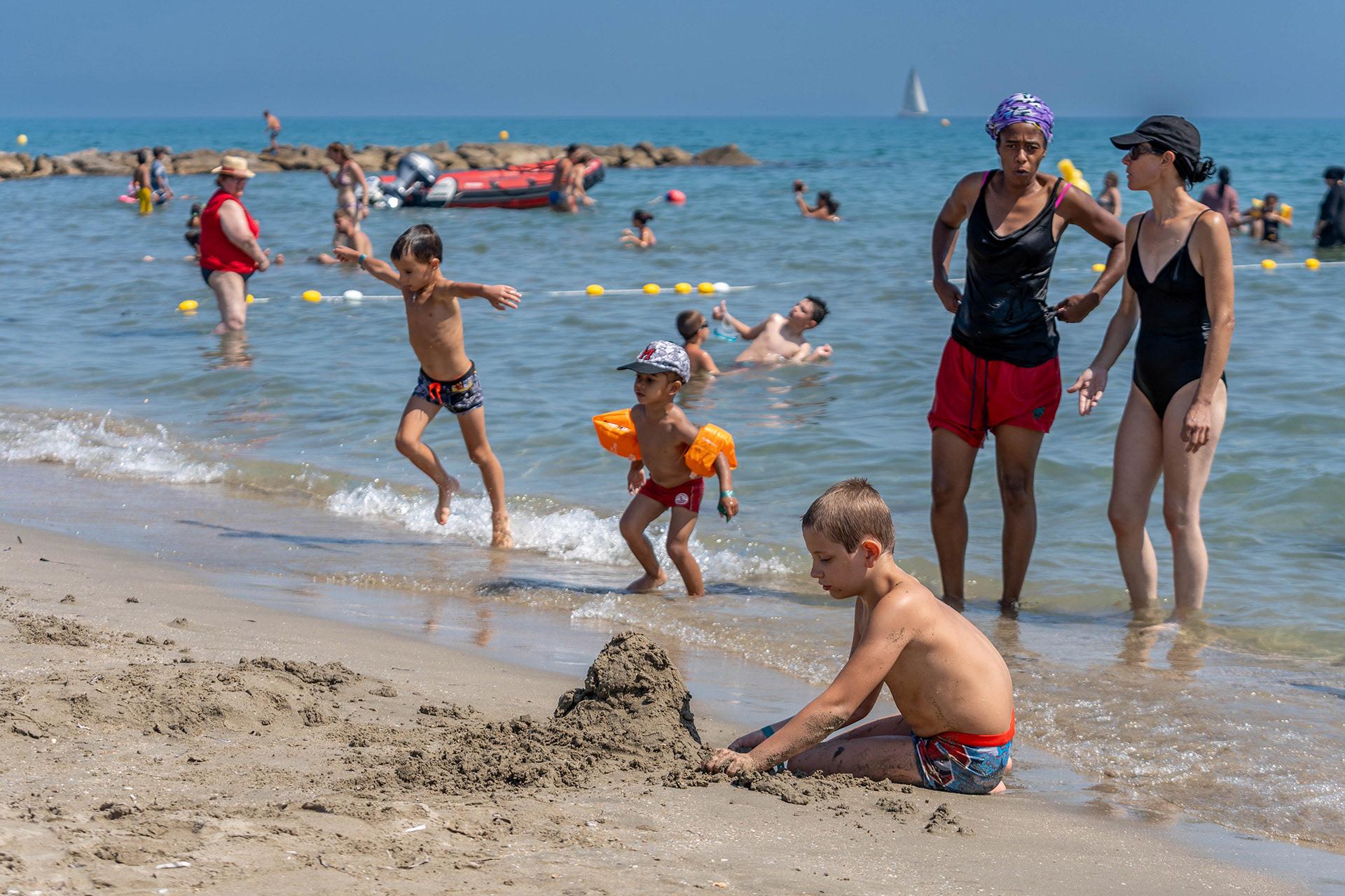 Sur la plage, les enfants papillonnent entre baignade, châteaux de sable et jeux de ballons et de raquettes. Hérault, un belle journée inoubliable pour 300 personnes