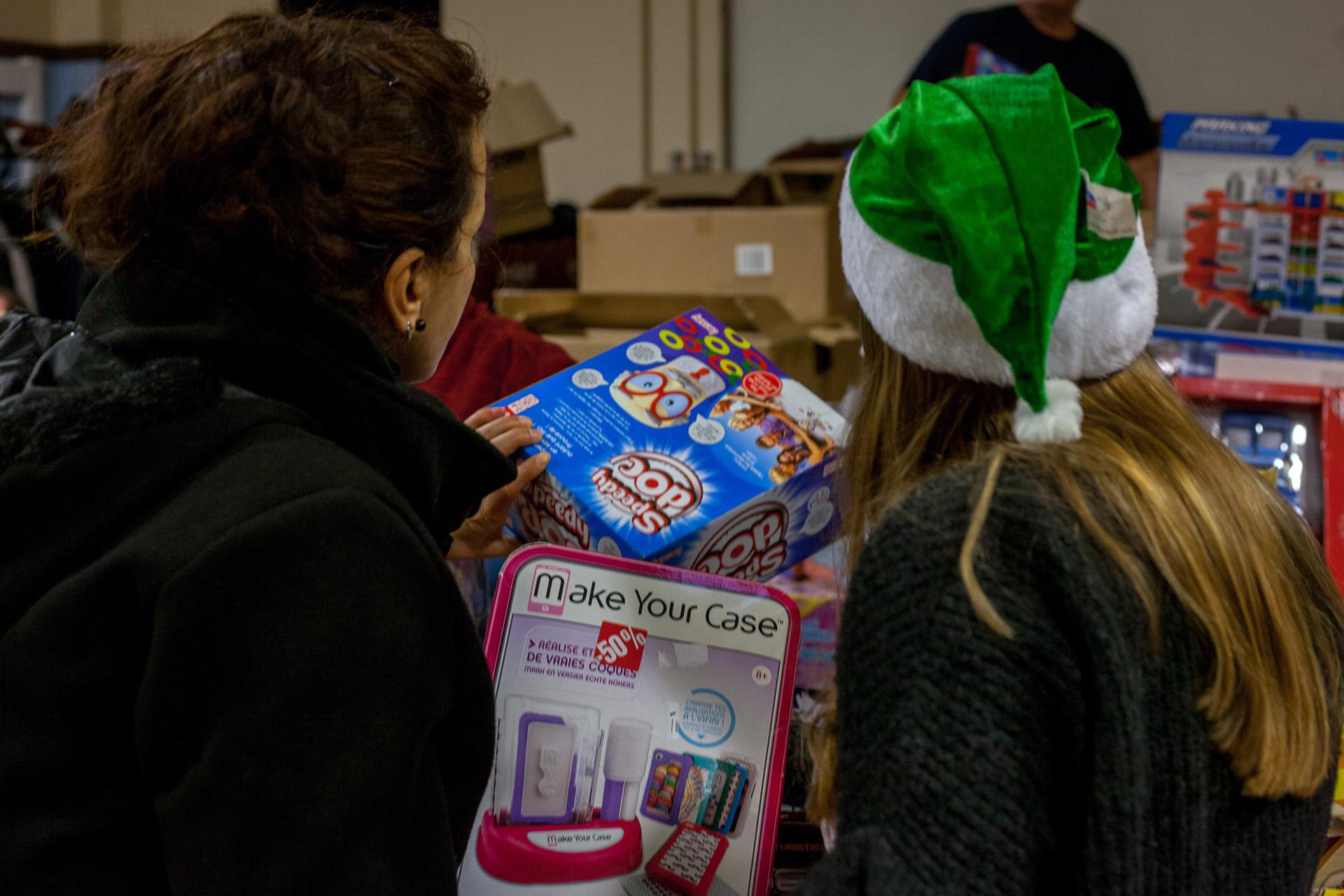 Les parents sont invités à choisir les cadeaux pour leurs enfants dans l'immense hotte du Père Noël verts du Mans.