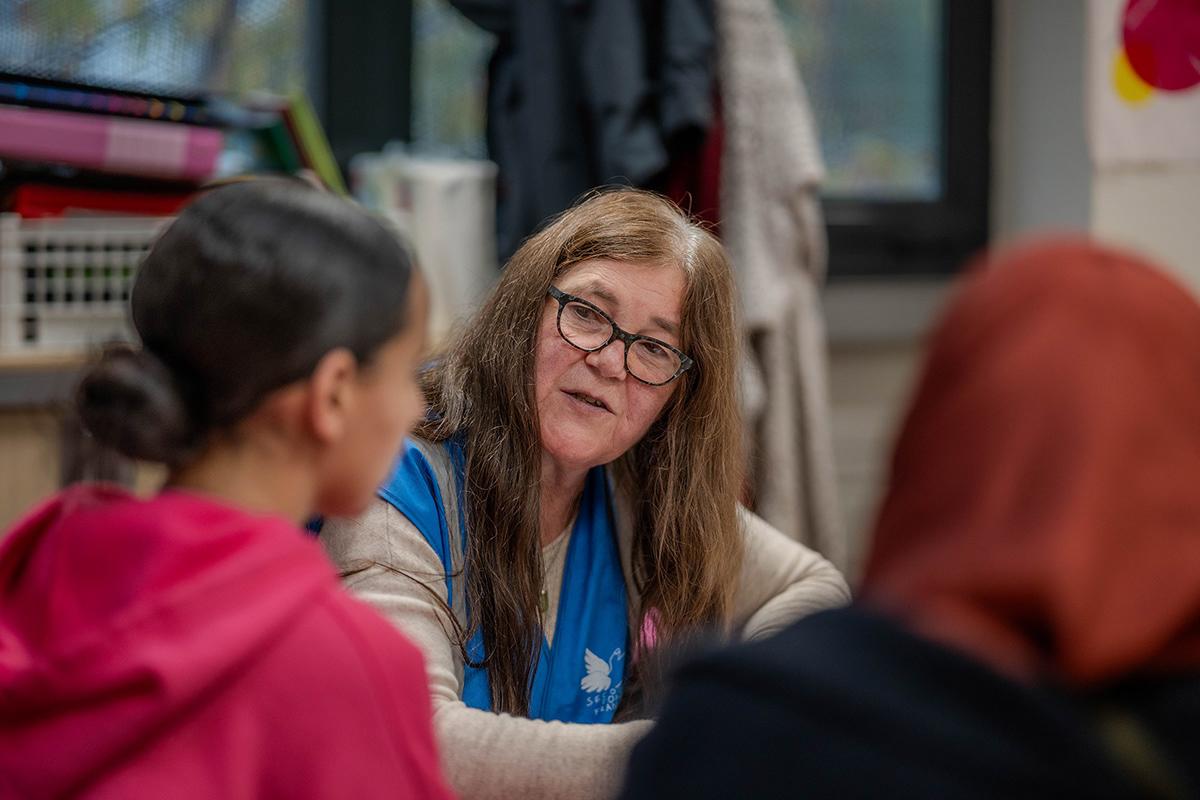 Zorha découvre l'accompagnement scolaire avec Catherine. Cette enseignante à la retraite est bénévole depuis 20 ans et coordonne une équipe qui suit une vingtaine d’enfants cette année. 