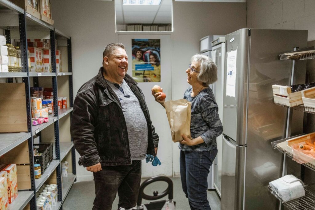 Moment de détente entre une personne aidée et une bénévole, au libre-service alimentaire à Lyon