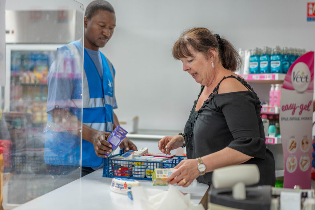 La Secrétaire générale de la Fédération avec un bénévole préparant un panier de denrées alimentaires pour un bénéficiaire de l'aide alimentaire.