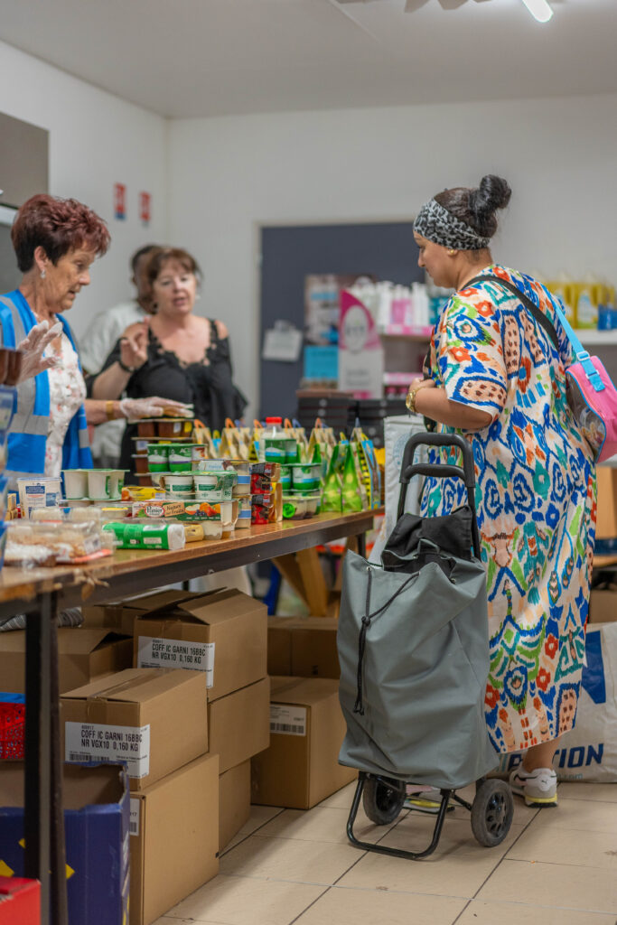 Femme accueillie avec un caddie choisissant ses aliments.