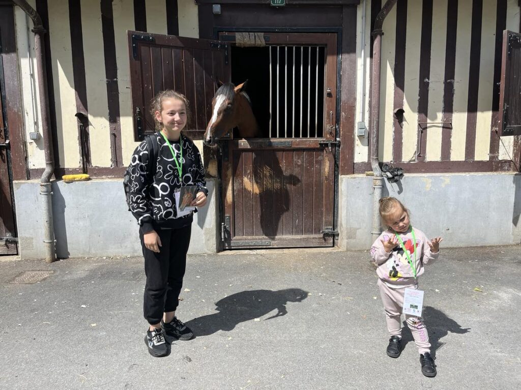 jeune fille devant les écuries avec un cheval