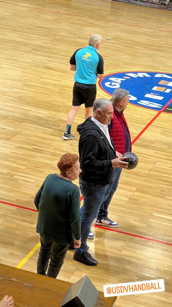 une femme, deux hommes et un arbitre, pour le lancement du match de handball.