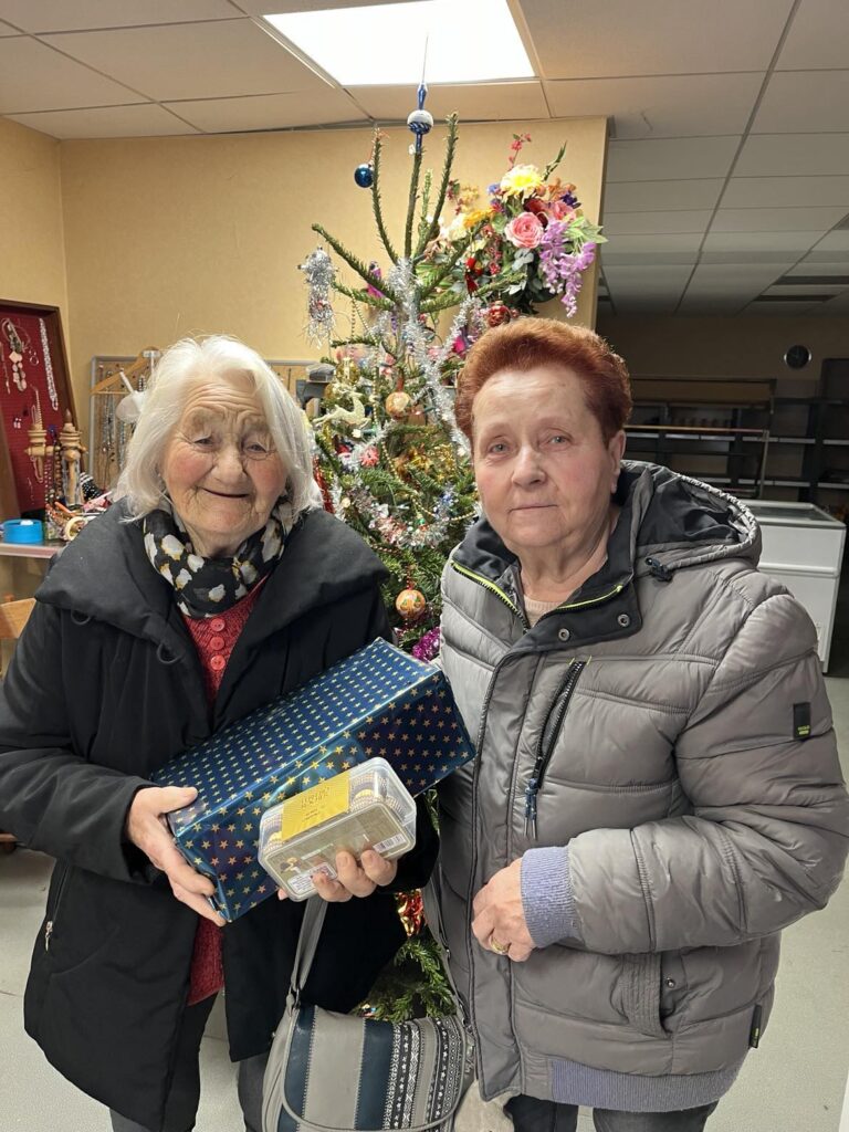 Petite mamie qui reçoit une boîte de Noël de la part d'une bénévole