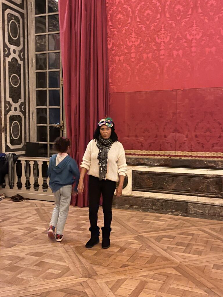une femme et une petite fille qui s'entrainent pour une danse dans une salle du château