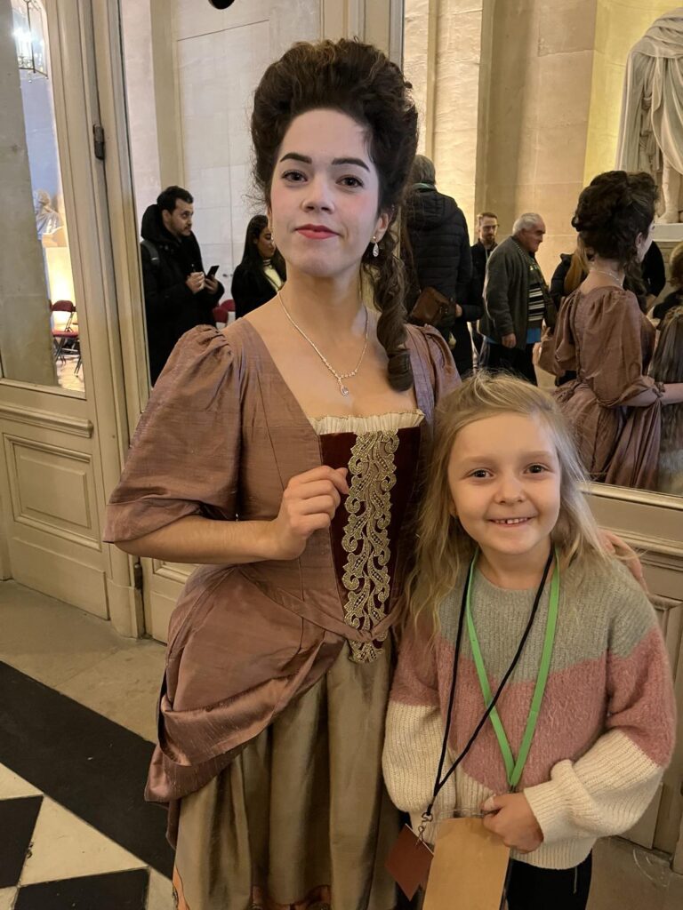 Une petite fille heureuse de poser au côté de belle demoiselle.