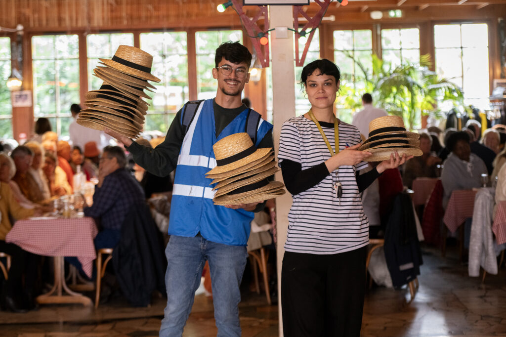 Bénévoles distribuant des chapeaux. © Béatrice Usseglio / Secours populaire