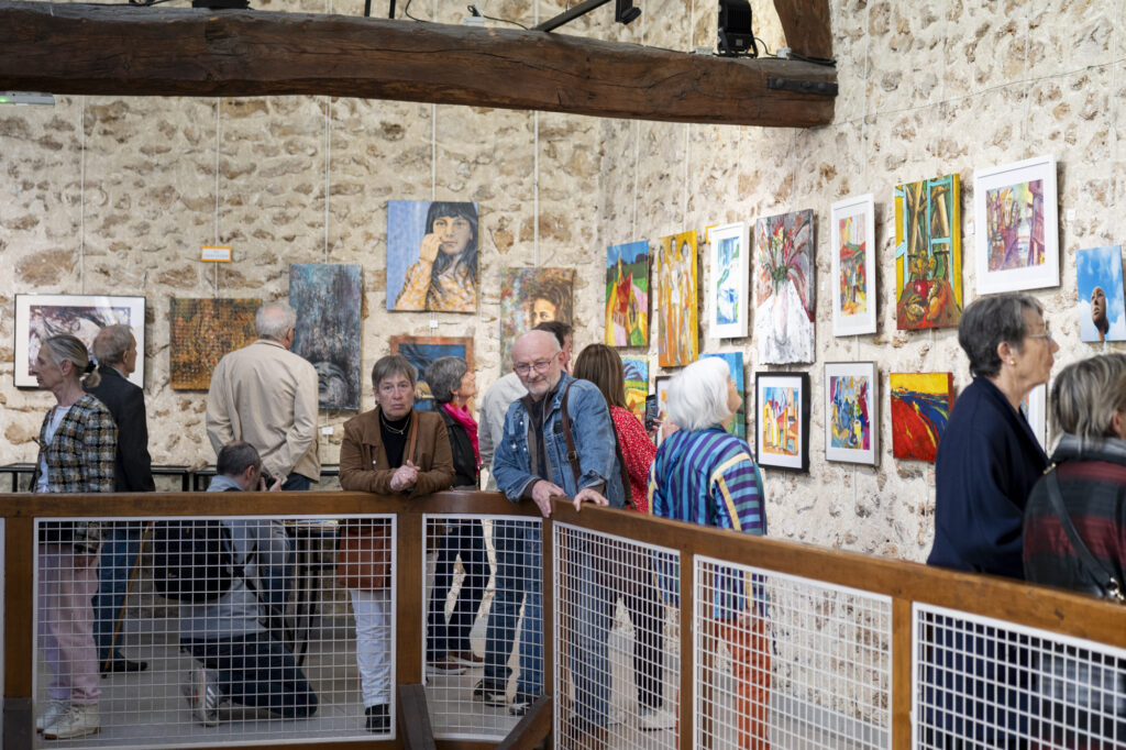 Un ensemble d'individus sur la mezzanine observant les œuvres d'art. © Béatrice Usseglio