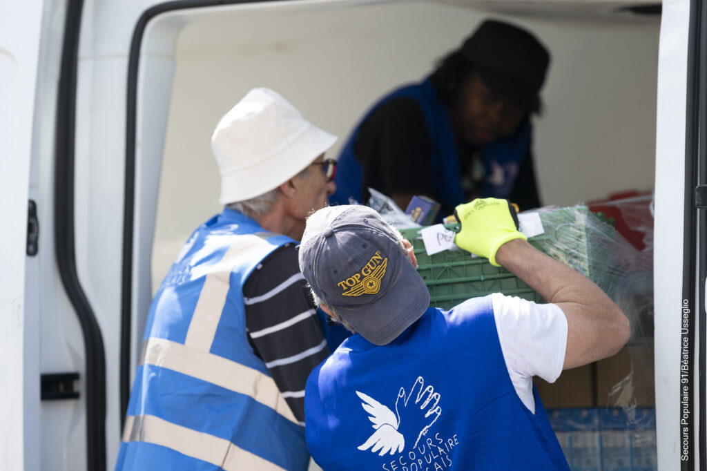 Des bénévoles du Secours populaire qui déchargent le camion