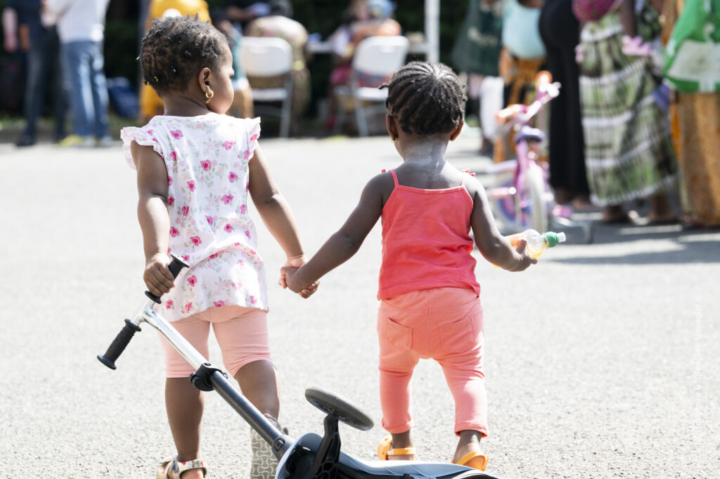 Deux enfant de dos qui se tiennent la main.